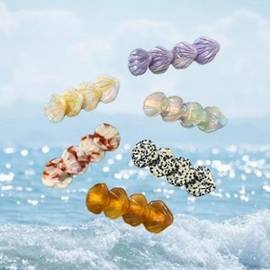 Detailed view of colorful shell-shaped hair claws in multiple marble and glitter finishes