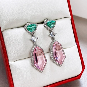 Macro shot of long drop earrings with pink and green crystals in a jewelry box