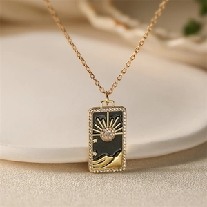 Golden tarot card pendant necklace with sun and star enamel motifs for beach vacations
