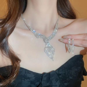 Silver leaf necklace and earrings set with tassel diamonds worn by a female model