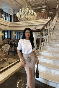 Detailed view of the elegant 3D flower embellishment and high slit on this beige skirt