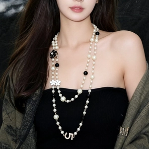 Detail of double-layer long pearl necklace with camellia flower and crystal U pendant
