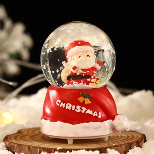 Boule à neige lumineuse de Noël avec socle bonnet de Père Noël et flocons festifs
