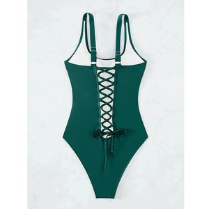 Detail view of the lace-up back design and cross straps on a dark green one-piece swimsuit