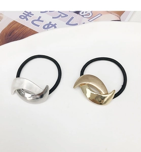 Detailed view of two minimalist crescent moon metal ponytail holders in gold and silver