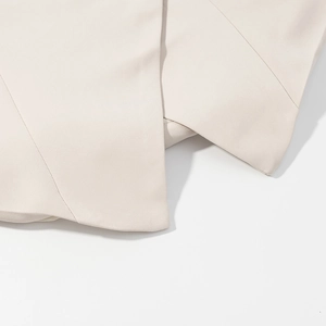 Detail showing high-quality stitching and smooth beige suit fabric on the hem