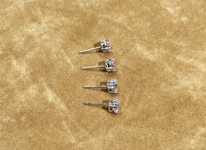 Macro shot of S925 sterling silver four-prong earrings with pink and white zircon stones
