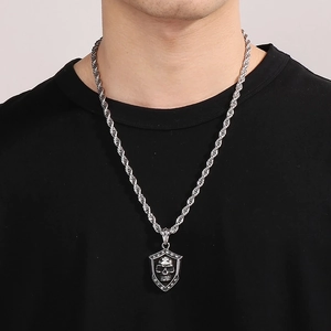 Macro shot of punk shield pendant with a skull and black stones on a silver rope chain