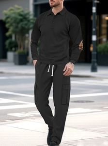 Detail of men's black corduroy tracksuit showing ribbed texture and cargo side pockets
