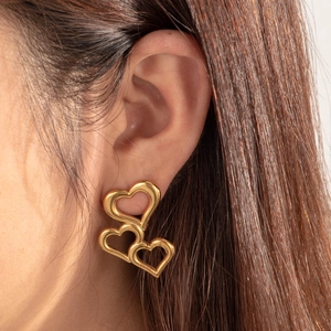 Elegant gold-plated stainless steel triple heart drop earrings worn on a female model