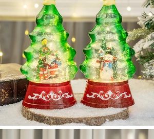 Detail of Christmas tree snow globe with Santa Claus, LED lights and glittery snow
