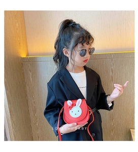 Detail of red rabbit crossbody bag for girls with cute bow and leather texture