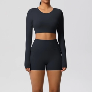Detail van zwarte yogaset met crop top met lange mouwen en sportshort met hoge taille