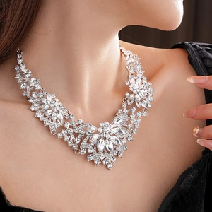Detailed view of luxury silver necklace with teardrop rhinestones on model neck