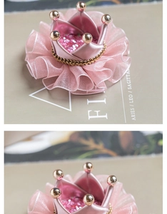 Detail of pink crown hair clip with sequins, organza ruffles and golden bead trim