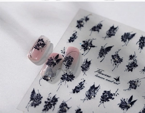 Macro detail of black butterfly nail stickers with floral patterns and silver rhinestones