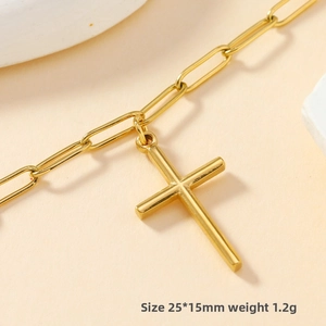 Detail of a 25x15mm golden stainless steel cross pendant on a paperclip chain