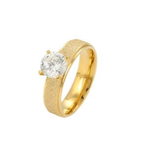 Macro detail of a gold frosted titanium steel ring with a sparkling central zircon stone.