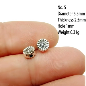 Close-up of 5.5mm silver alloy sunflower spacer beads with precise size measurements