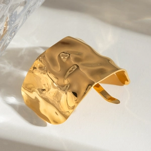 Minimalist gold stainless steel hair pin with irregular hammered texture on white stone