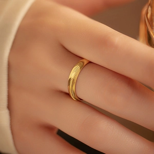 Elegant gold S925 silver ring with spiral brushed texture on model's index finger