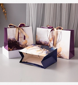Detail of luxury marble pattern gift bags with silk ribbons and twisted rope handles