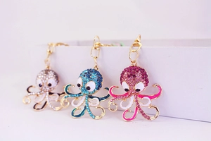 Detailed macro view of crystal-encrusted octopus keychains with enamel finish accents