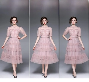 Détail de robe rose en dentelle avec broderie florale et jupe en tulle à volants