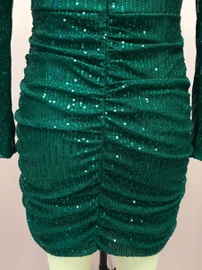 Close-up detail of emerald green sequin dress with elegant ruching and slim fit design