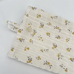 Dettaglio della borsa per cellulare in chiffon a fiori con bottone di perla e trama