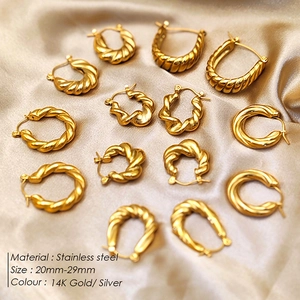 Detailed macro view of 14K gold plated stainless steel twisted hoop earrings on silk