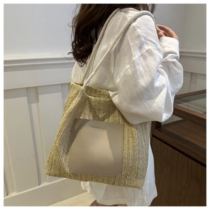 Modische Stroh-Schultertasche mit Lederpatch am Modell für das tägliche Pendeln gezeigt
