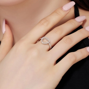 Close-up of S925 sterling silver heart ring with pavé zircons worn on model's finger