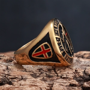Detail of vintage gold knight shield ring with red cross and biblical scripture engraving