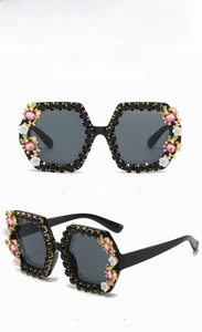 Detail of black hexagonal sunglasses with pink and white 3D flowers and rhinestones