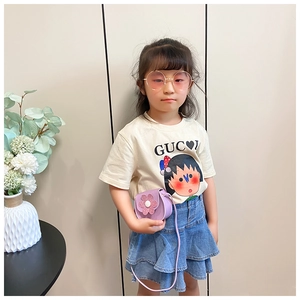 Close-up of a beige cotton kids t-shirt with cartoon print and purple flower crossbody bag