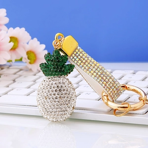 Detail of pineapple keychain with green and white rhinestones on a metal base