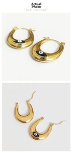 Detail view of gold Evil Eye hoop earrings with black and white enamel drip oil finish