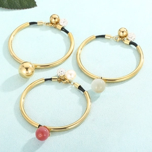 Detailed macro view of minimalist titanium steel cord bracelets with pearls and gold beads