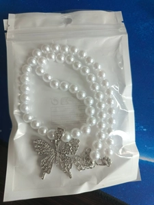 Detailed close-up of a butterfly pendant pearl necklace with micro-pave cubic zirconia