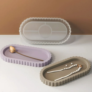 Oval wave edge silicone tray mold with finished resin plaster plates on a table