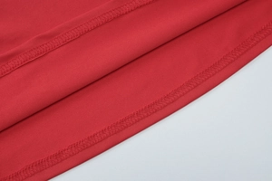 Detailansicht aus rotem Strickstoff mit hochwertiger Rollsaumnaht und feiner Textur