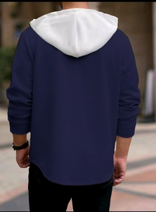 Rear view of navy blue men's hoodie showing white hood and embossed jacquard fabric texture