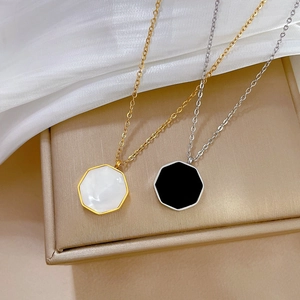 Detail of gold and silver necklaces with geometric shell pendants on silk background