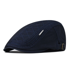 Detail of navy blue cotton ivy cap featuring diamond quilt stitching and metal side logo