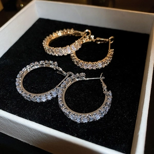 Macro shot of gold and silver hoop earrings with pave set square cubic zirconia stones