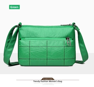 Detailed close-up of green faux leather shoulder bag featuring textured grid stitching