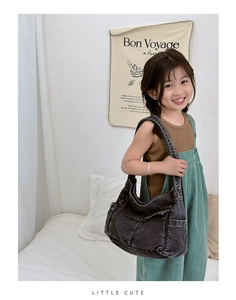Kids vintage dark grey denim hobo bag worn by a child in a casual home setting