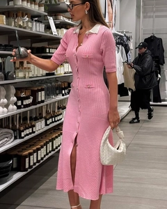 Detailed view of pink knitted dress featuring white contrast collar and pearl button pockets