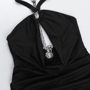 Close-up of black halter dress featuring a bold silver chain necklace and ruched fabric